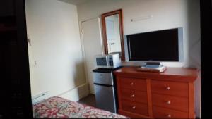 Star Inn by Elevate Rooms في شلالات نياجارا: غرفة نوم مع تلفزيون وخزانة مع تلفزيون gmxwell gmxwell gxwell
