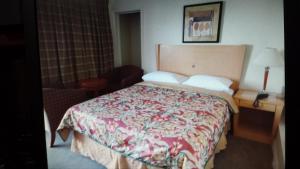 a bedroom with a bed with a red and white blanket at Star Inn by Elevate Rooms in Niagara Falls