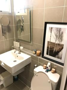 bagno con lavandino, servizi igienici e quadro di Stay in Style at Oasis a Chiang Mai