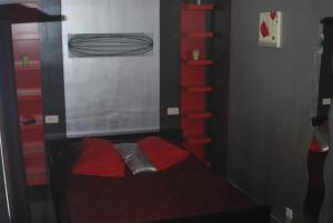 a small bedroom with a bed and red shelves at Le K d'Or in Bouillon