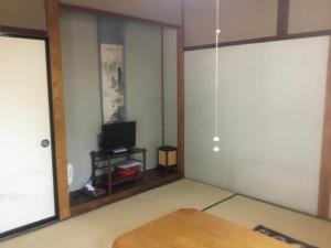 a living room with a tv and a table at Ryokan Sarashinaya in Kiso