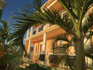 a yellow building with palm trees in front of it at Sunshine Villa Mauritius in Flic-en-Flac