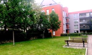 un parc avec un banc devant un bâtiment dans l'établissement le topaze, à Colmar