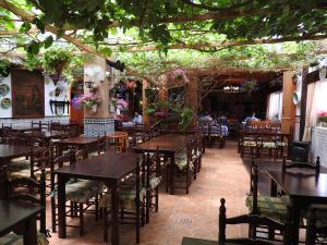 un restaurante con mesas de madera, sillas y plantas en Bungalow Lomas Del Golf, en San Miguel de Salinas