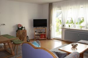 ein Wohnzimmer mit einem TV und einem Tisch in der Unterkunft Apartments Eichenweg in Rednitzhembach