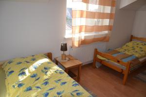 1 dormitorio con 2 camas y ventana en Apartament Centrum, en Augustów