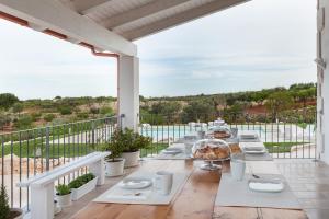 una mesa larga en un balcón con vistas al océano en B&B A Casa di Pier, en Castellana Grotte