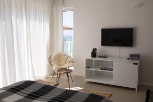 a bedroom with a tv and a chair and a bed at Sea Sense Boutique Hotel & Wellness in Sozopol