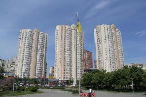 two tall white buildings in a city with a park at Solo Apartment Dragomanova in Kyiv