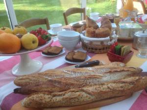 a table with a plate of bread and a basket of fruit at Chez Pierre et Caroline in Les Herbiers