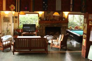 a living room with a fireplace and a pool table at Hostel La Angostura in Villa La Angostura