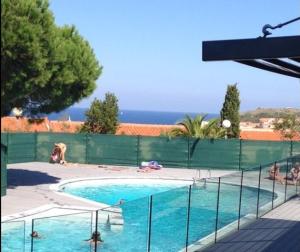 a swimming pool with a green fence around it at 41 Les Imperiales in Collioure