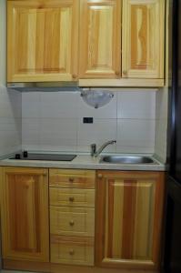 Una cocina con gabinetes de madera y un fregadero. en Apartmani Vidic, en Zlatibor 55 fotos más