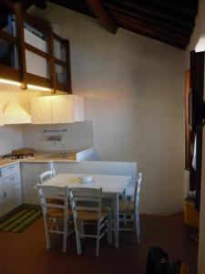 - une cuisine avec une table et des chaises dans la chambre dans l'établissement Maisonette Tommy, à Île de Capraia