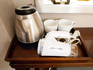 a coffee maker and cups on a wooden shelf at Hotel Park Hill Myeongdong in Seoul