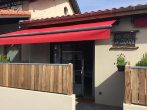 a restaurant with a red awning and a fence at Les studios du Centre in La Teste-de-Buch