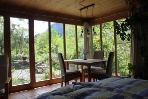 a bedroom with a table and chairs and a table and windows at Dunkel Blaue Maus in Meiringen