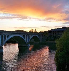 eine Brücke über einen Fluss mit Sonnenuntergang in der Unterkunft Hôtel du Fort in Huy