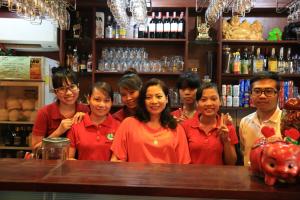 a group of people standing behind a bar at Vien Dong Hotel 2 in Ho Chi Minh City