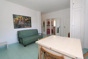 a living room with a green couch and a table at Conchiglia apartments in Lido di Pomposa