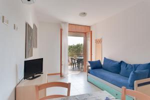 un soggiorno con divano blu e TV di Aparthotel Costa Paradiso a Lido Adriano