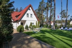 a house with a hammock in the yard at Zwierzyńscy Residence in Pobierowo