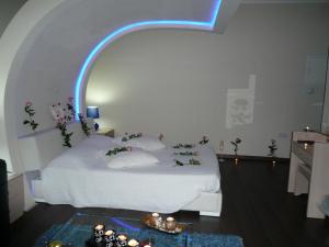 a bedroom with a white bed with a blue light at Esperando in Maroni