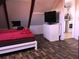 Habitación pequeña con cama roja y TV de pantalla plana. en Sleep in Hamburg St. Pauli, en Hamburgo