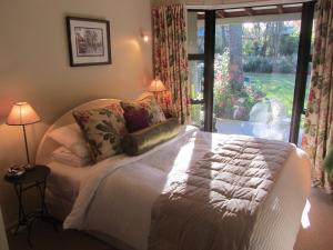 um quarto com uma cama e uma janela grande em Oldfields em Geraldine
