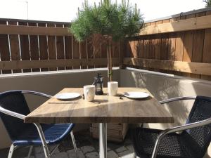 a wooden table and chairs on a patio at Les studios du Centre in La Teste-de-Buch