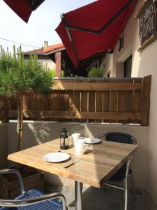 a wooden table and chairs on a patio at Les studios du Centre in La Teste-de-Buch