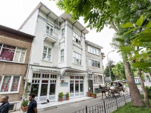 a horse drawn carriage in front of a house at Cenar Konak Butik Hotel in Buyukada