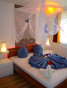 a bedroom with a bed with blue blankets and two lamps at Bálint & Timi wellness apartman in Siófok