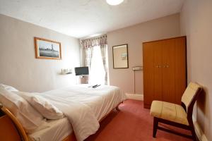 a bedroom with a bed and a cabinet and a window at Royal Oakwell Hotel in Blackpool