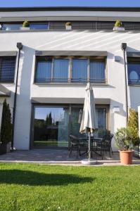 Un paraguas sentado frente a una casa en Ferienwohnung Fischbach, en Friedrichshafen