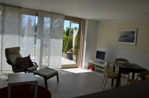 Una sala de estar con una mesa y sillas y un televisor. en Ferienwohnung Fischbach, en Friedrichshafen