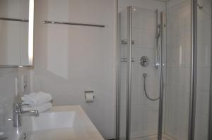 een badkamer met een glazen douche en een wastafel bij Ferienwohnung Fischbach in Friedrichshafen