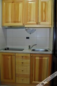 Una cocina con gabinetes de madera y un fregadero. en Apartmani Vidic, en Zlatibor