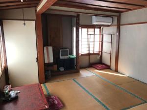 um quarto vazio com um quarto com uma televisão em Niko Ryokan em Aizuwakamatsu