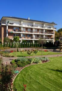 a large building with a garden in front of it at Bálint & Timi wellness apartman in Siófok