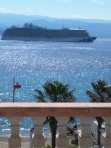 a cruise ship in the water with palm trees at Blue Eden Strait in Messina