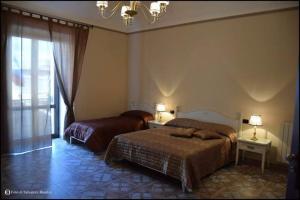 a bedroom with two beds and a chandelier at b&b Caravella in Mezzojuso