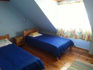 a attic bedroom with two beds and a window at Kuus Tuba in Leisi