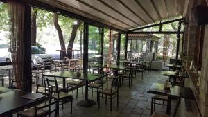 a restaurant with tables and chairs in a room with windows at Hani Zemenou in Arachova