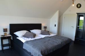 a bedroom with a large bed with two pillows at Black Pearl in Büsum