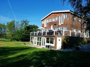 a large brick building with a balcony on a lawn at Stege Nor in Stege