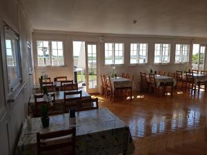 uma sala de jantar com mesas, cadeiras e janelas em Stege Nor em Stege