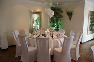uma sala de jantar com uma mesa e cadeiras brancas em Burgdorfs Hotel & Restaurant em Hude