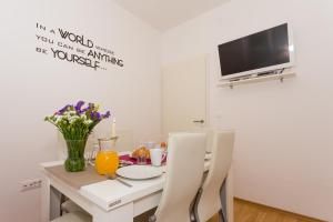 a dining room with a table with a vase of flowers at Ante Apartments in Podstrana