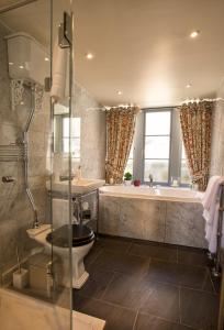 ein Badezimmer mit einer Badewanne, einem WC und einem Waschbecken in der Unterkunft Mingary Castle - Restaurant with Rooms in Kilchoan